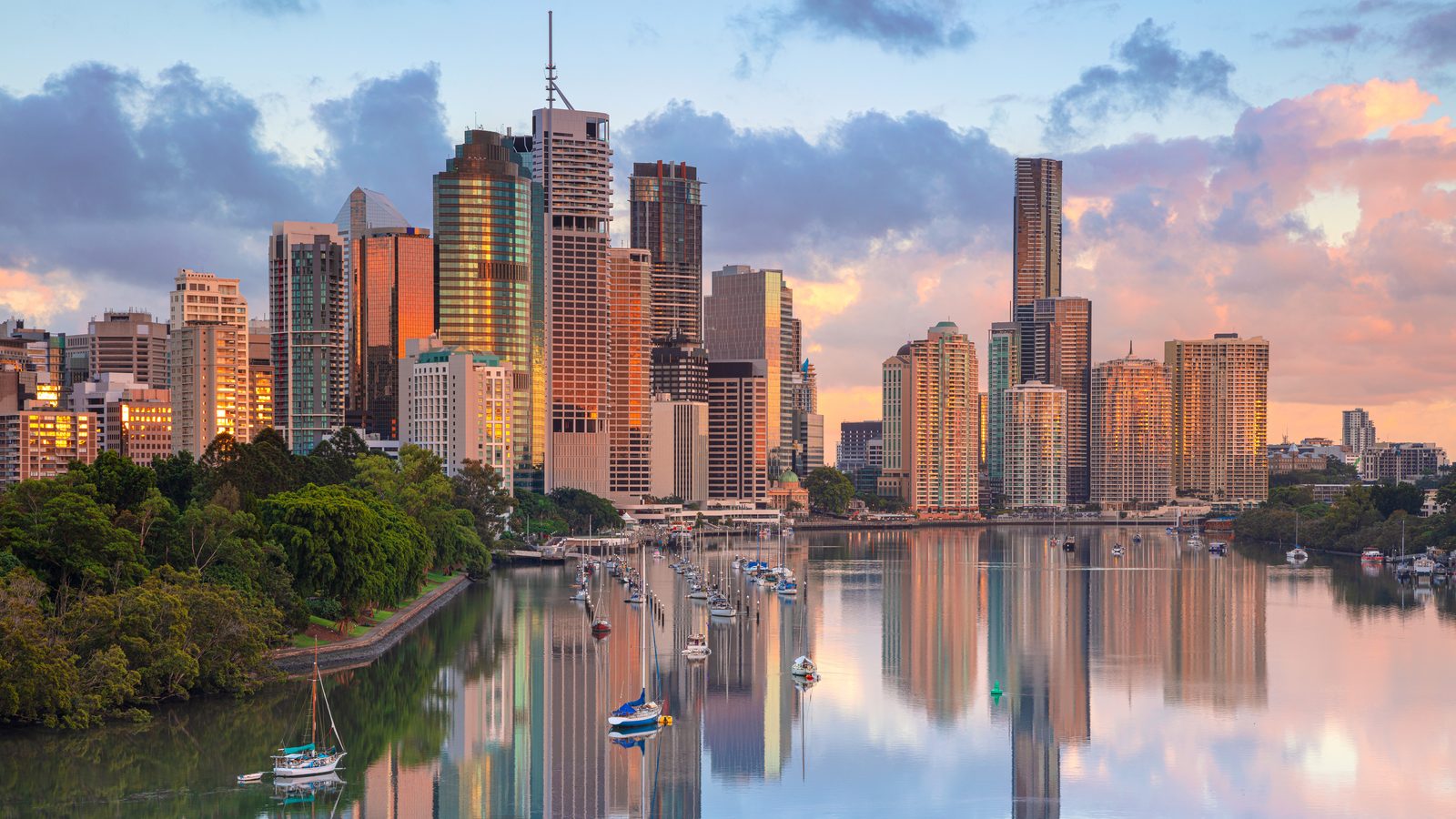 Aerial view of the Brisbane River curving towards the Brisbane CBD skyline.