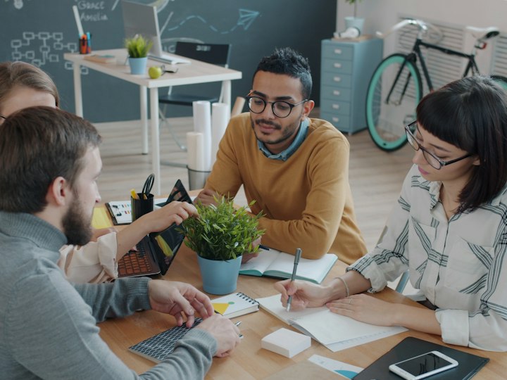 Researchers discussing results together around a table.